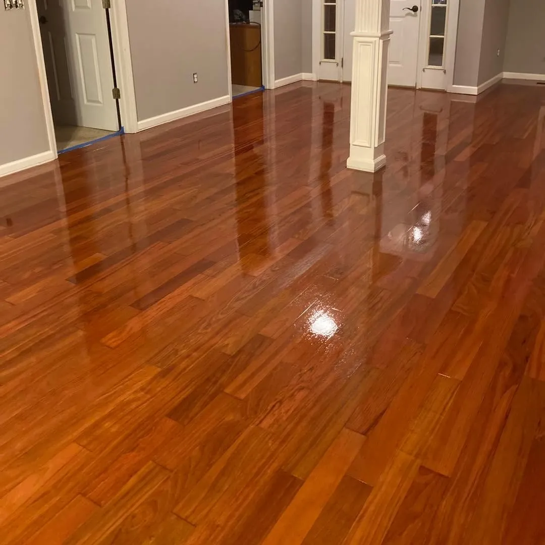 Glossy refinished hardwood floor in a warm amber finish running down a hallway